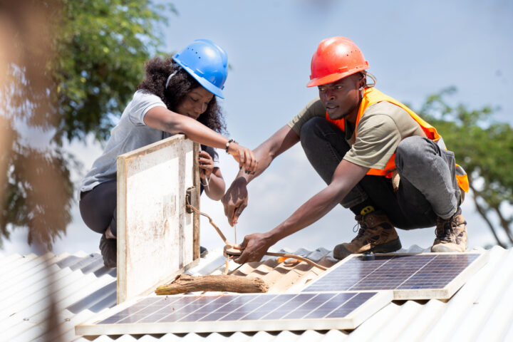 Patapia staff inspecting solar panels installed for some of their clients in Kyempango village, Kamwenge district – Uganda. Miriam Watsemba/Ashden