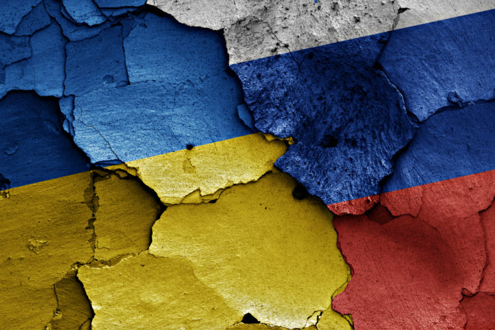Depositphotos - Ukraine and Russian flags on cracked wall