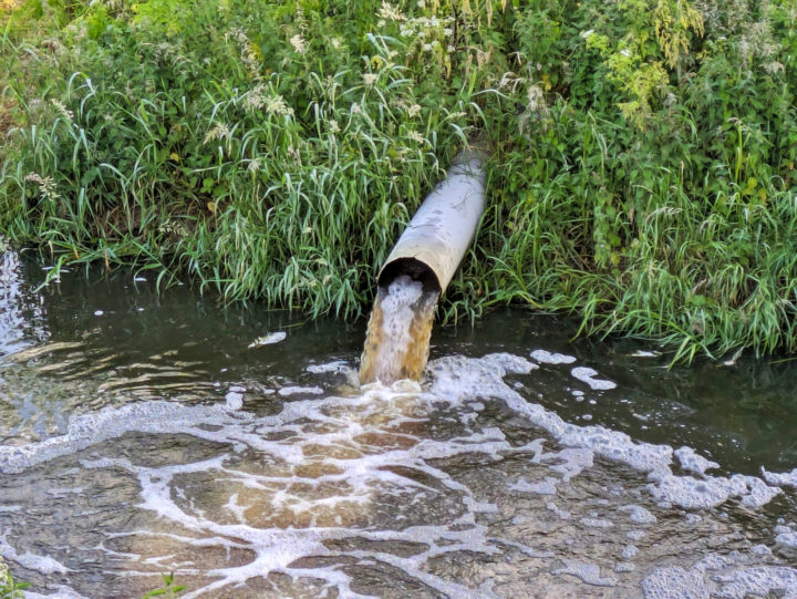 Pollution outflow pipe into river | baldrick69 | Depositphotos