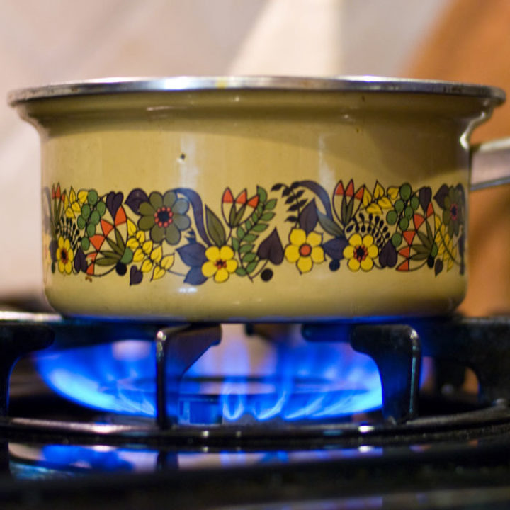 Pot cooking over a lit hob